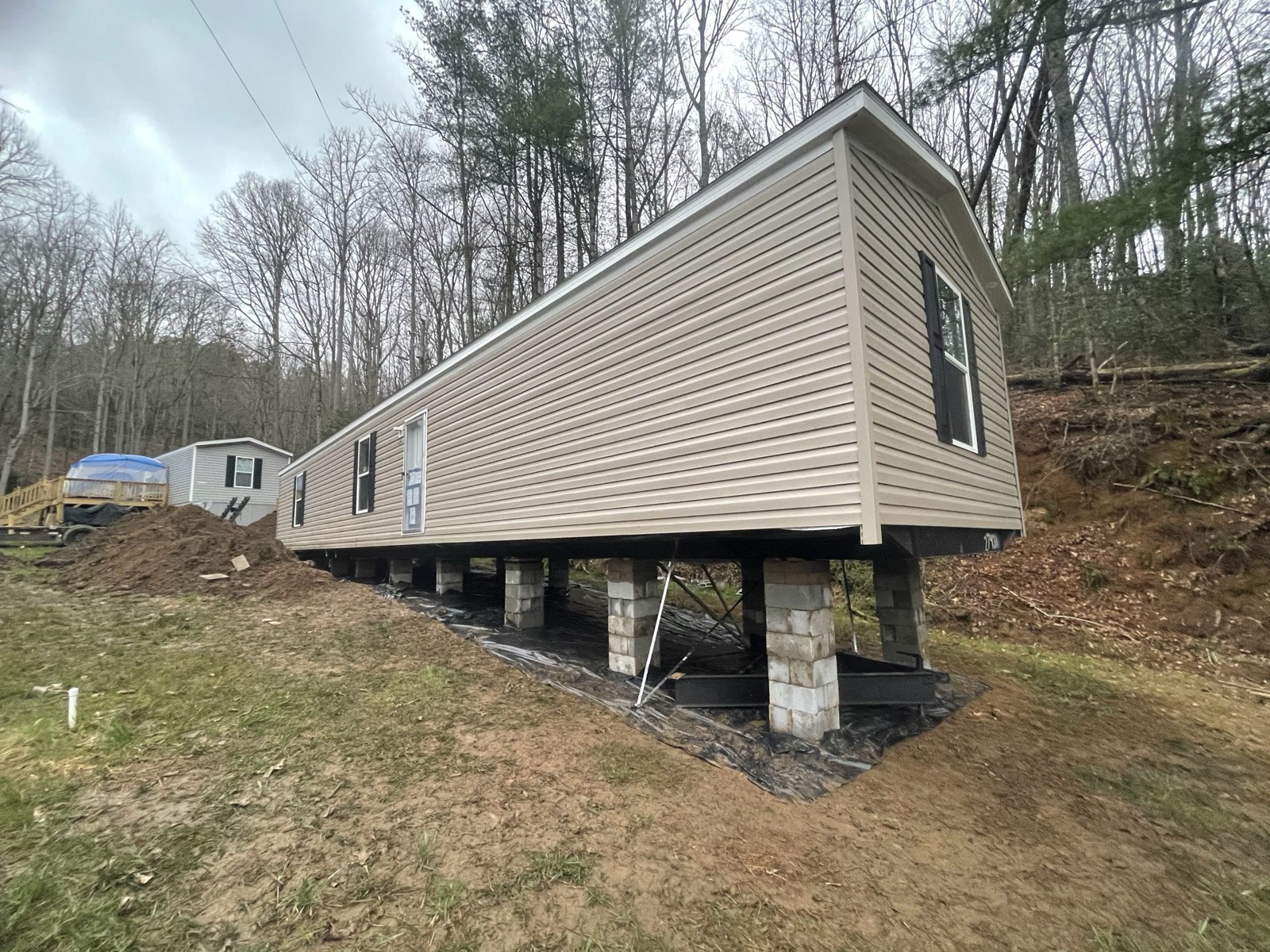 A home on a hillside site sloped for drainage, with vapor barrier underneath